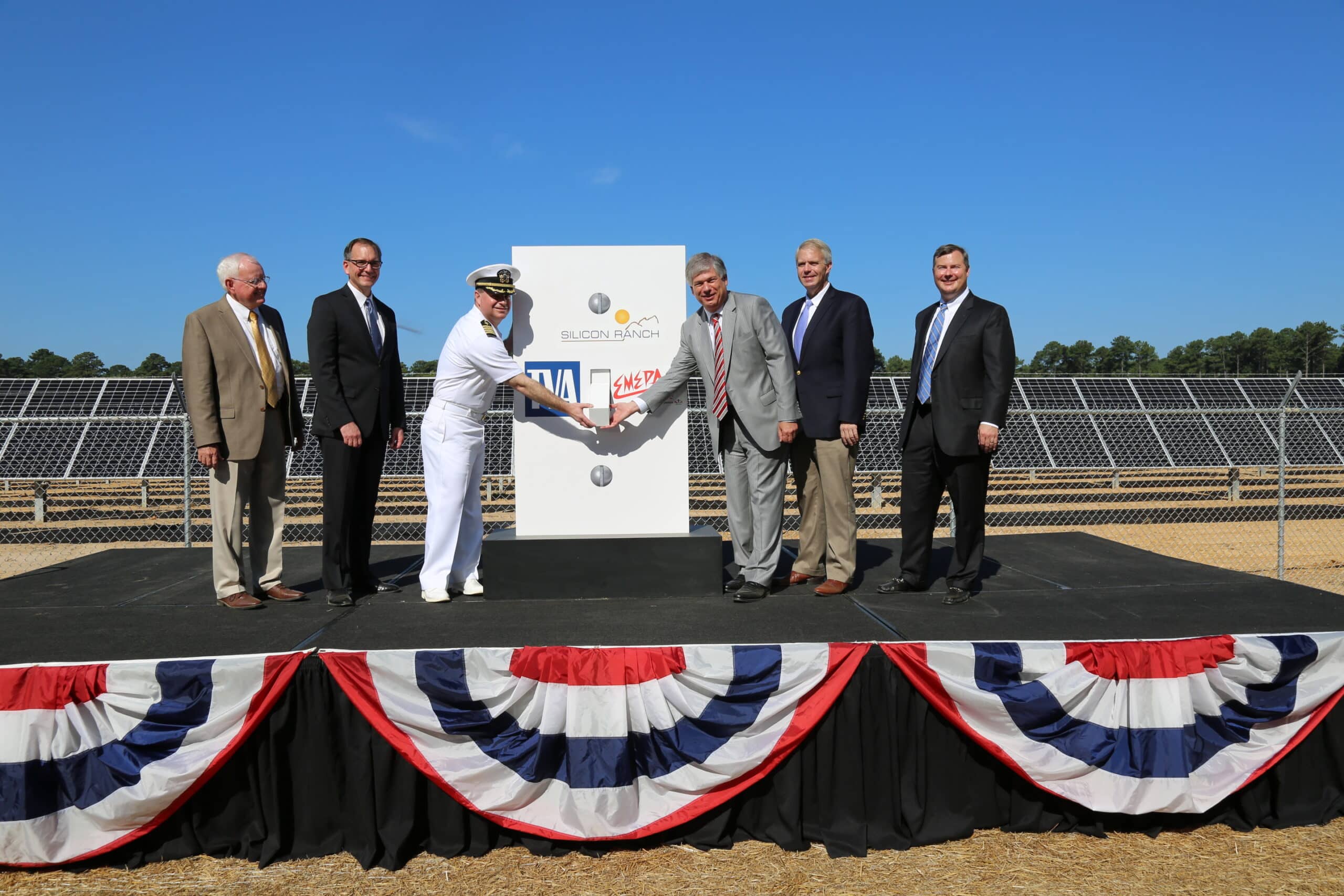 Notable ceremony presenters shake hands after the new solar farm is completed at Meridian Naval Facility