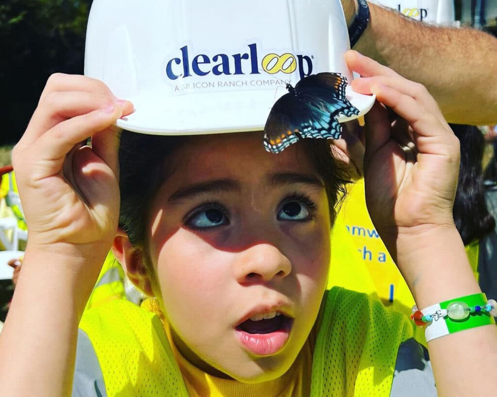 Student with Butterfly at the Jackson II Solar Farm - Flip the Switch Event